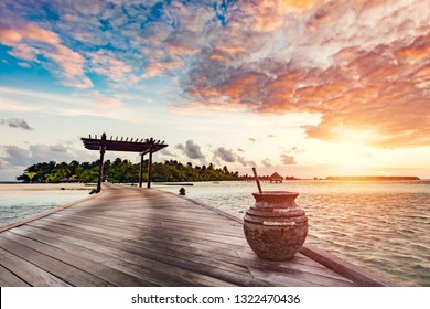 Wooden jetty on a blue ocean at sunset. Tropical travel destinations. Romantic view. Maldives.