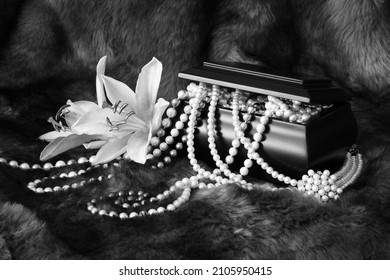 A Wooden Jewelry Box Overflowing With Pearl Jewelry, Accented With Lilies And Photographed Closely With A Faux Fur Underlay.