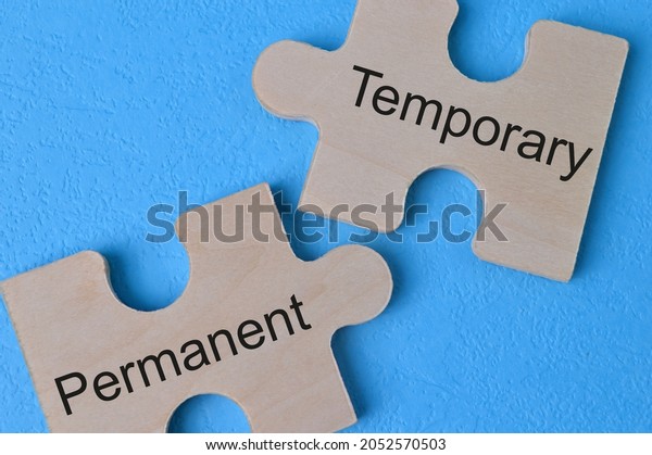 Wooden\
jigsaw puzzle with text TEMPORARY and\
PERMANENT