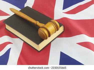 Wooden Judge Gavel On Black Legal Book On UK Flag Background. United Kingdom Laws Concept.	