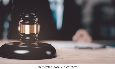 Wooden judge gavel on table ,justice in punishment of offenses and criminal verdicts ,concept of law and justice ,Lawyer or judge examining documents ,legal contract consulting ,court proceedings

