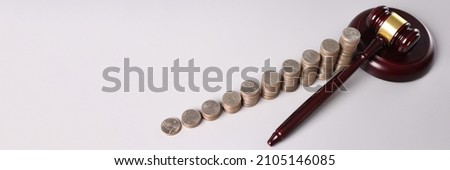 Wooden judge gavel and stacks of coins on table. Criminal offenses in the economic sphere concept