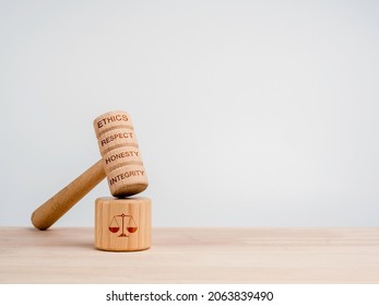 A wooden judge gavel with words, ethics, respect, honesty, and integrity with the soundboard with scales icon, toys on wooden table, white background with copy space, minimal style. Justice concept. - Shutterstock ID 2063839490