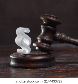 Wooden Judges Gavel And Symbol Of Law And Justice On Table In A Courtroom Or Law Enforcement Office On Dark Background