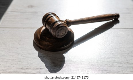 Wooden judicial gavel on a wooden laminate.