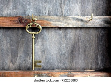 Wooden key holder. Metal hanging hook vintage door key. Key antique bronze. The texture of the tree. Grey distressed style.