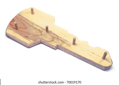 A Wooden Key Shaped Key Holder With Pegs.