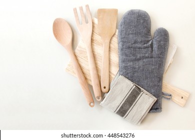 Wooden kitchen utensils, potholder, glove and napkin on table, top view