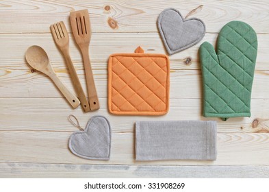  Wooden kitchen utensils,potholder, glove and napkin on wooden table,top view 