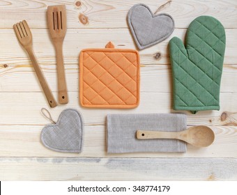  Wooden kitchen utensils,potholder, glove and napkin on wooden table,top view