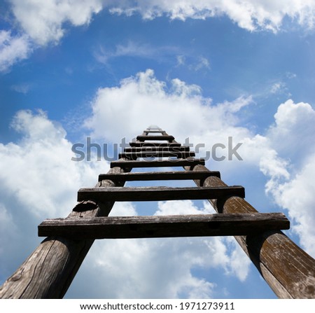Wooden ladder leading high up in the heavenly looking blue sky and white clouds, success concept 
