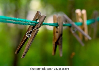 Wooden Laundry Tongs Unaligned On The Green Rope