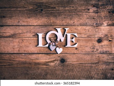 Wooden letters forming word LOVE written on wooden background. St. Valentine's Day. two hearts