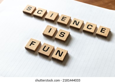 Wooden Letters Spell Out 'science Is Fun' On A Blank White Lined Notepad. Hardwood Desk Surface. Back To School, In-person Learning, Online Learning, Studying, No People, Studies, Primary School.