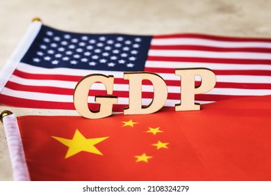 Wooden Letters Text On China And America Flags Background, USA Vs China GDP Comparison Concept