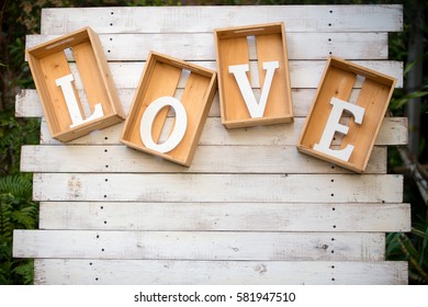 Wooden letters word LOVE in wooden box, hanging on brick wall background, can be use to background, wallpaper, greeting card, template and screensaver. Love anniversary concept and signature.