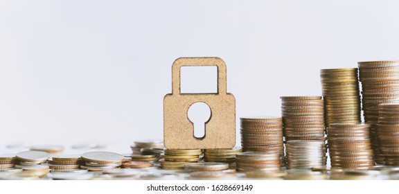 Wooden lock and stack of coins in concept of savings. Pension fund, 401K, Passive income, Investment and retirement concept. savings and making money. Risk management.