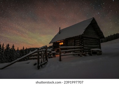 Wooden log cabin in winter Carpathian mountains under starry sky - Powered by Shutterstock