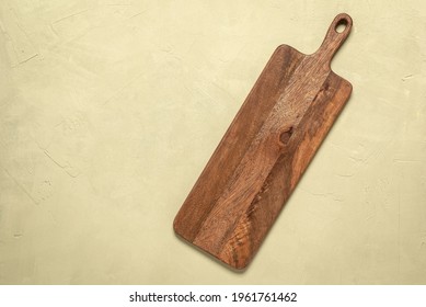 Wooden Long Empty Cutting Board On A Beige Concrete Background. Top View, Flat Lay