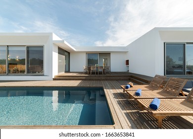 Wooden Lounge Chairs In Modern Villa Pool And Deck