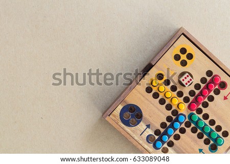 Wooden Ludo on Brown Paper Background. Copy Space for Text.