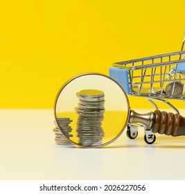 Wooden Magnifier And White Coins On The Table. Income Growth Concept, High Percentage Of Investment. Search For New Sources Of Income, Subsidy