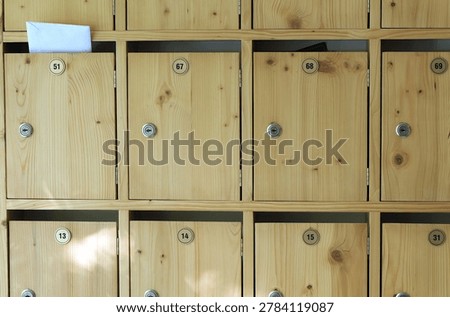 Wooden mailboxes forming a secure storage system for receiving letters and parcels in a contemporary building, illustrating communication, privacy, and postal services
