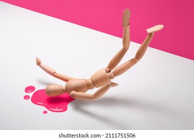 Wooden man clumsily fall and badly hit head lose a lot of blood. Puddle of blood bright pink color. Unhappy accident on white and pink background.