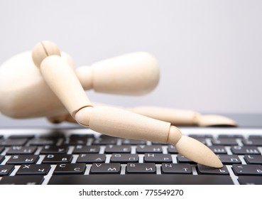 wooden man with computer keyboard