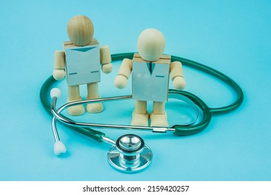 Wooden man. Concept: Doctor and stethoscope on a blue background.
