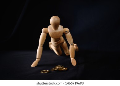 Wooden man desperately looking at some coins