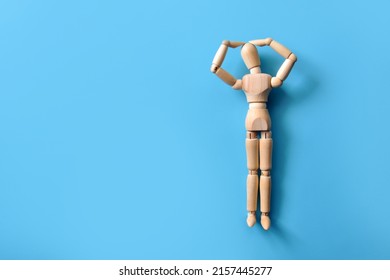 The wooden man is holding his head. A symbol of human problems and headaches
