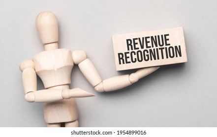 Wooden Man Shows With A Hand To White Board With Text Revenue Recognition, Concept