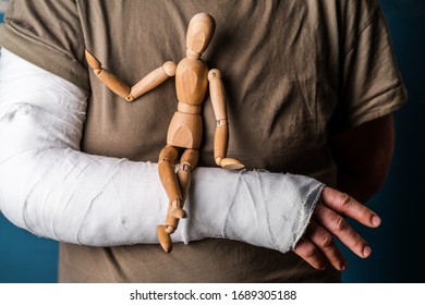 Wooden Man Sits On A Gypsum Female Hand