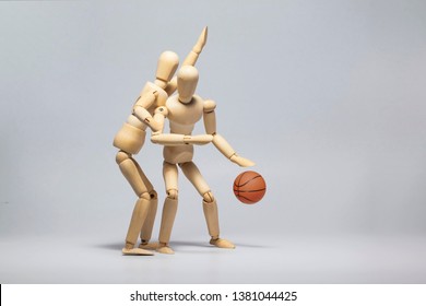 Wooden mannequin with basketball ball on gray background - Powered by Shutterstock