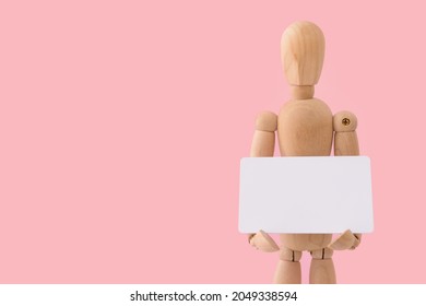 Wooden mannequin with blank card on color background - Powered by Shutterstock