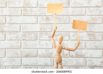 Wooden mannequin with blank placards on brick background - Powered by Shutterstock