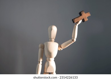 wooden mannequin with cross on his hand - Shutterstock ID 2314226133