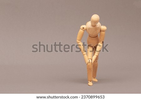 Wooden mannequin demanstruates pain in knee, joint with space for text. Layout. Stock photo © 