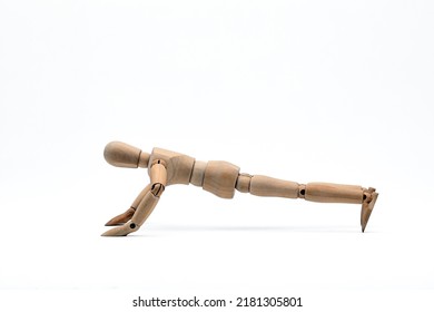 a wooden mannequin doing exercises on white background. Push-up exercise.	 - Shutterstock ID 2181305801