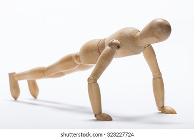 Wooden mannequin doing push-up exercise - Powered by Shutterstock