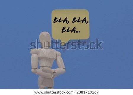 Wooden mannequin dummy isolated on blue background and with message bubble above him with words BLAH BLAH BLAH illustrating chatty extroverted persons and with copy space for text.