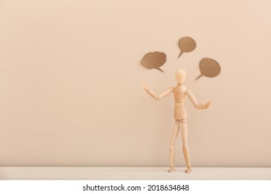 Wooden mannequin with empty speech bubbles on color background - Powered by Shutterstock