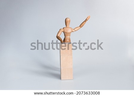 wooden mannequin giving a speech behind tribune