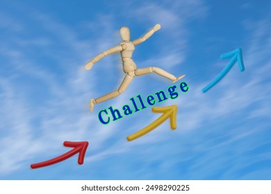 A wooden mannequin jumping over the word "CHALLENGE" against a blue sky background - Powered by Shutterstock