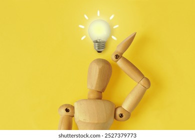 Wooden mannequin with light bulb - Concept of ideas and creative thinking - Powered by Shutterstock