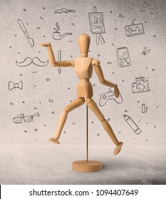 Wooden mannequin posed in front greyish background and hobby related scribbles behind it