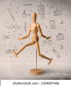 Wooden mannequin posed in front greyish background and hobby related scribbles behind it
