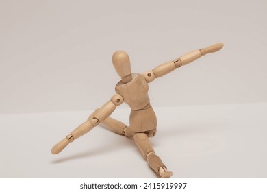 A wooden mannequin sits on twine with its arms outstretched. High quality photo - Powered by Shutterstock