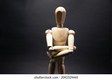 The wooden mannequin stand cross one's arm. on a black background - Powered by Shutterstock